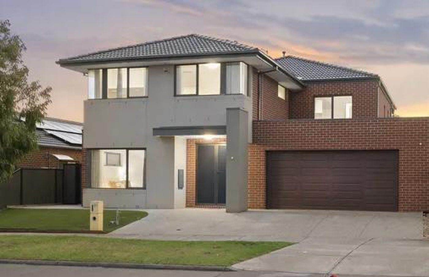 Two storey rendered and brick home with a double garage and landscaped front lawn in Truganina, Victoria